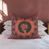 Square pillow cover featuring a golden skeleton hand holding a coral hibiscus flower, surrounded by fan-shaped coral motifs on a black background in an Art Nouveau style.