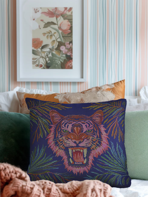 Square woven pillow featuring a fierce pink tiger with bared fangs against electric blue background surrounded by psychedelic jungle leaves. Textured tapestry design creates vibrant maximalist tiger decor perfect for gothic or eclectic home styling.