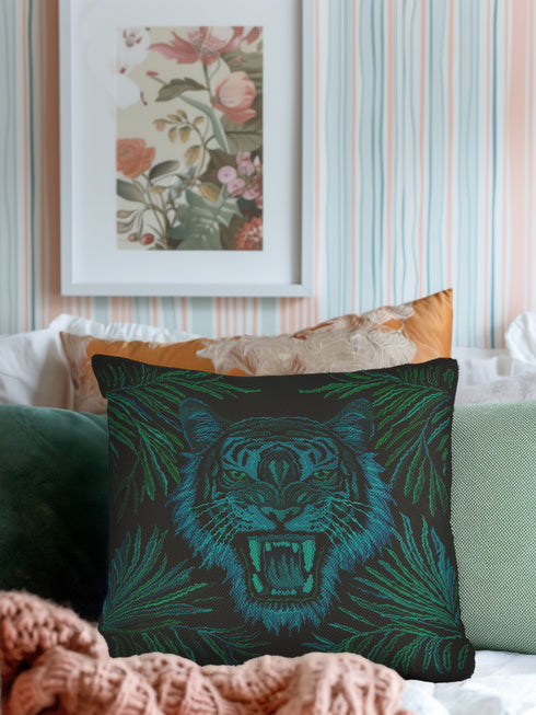 Square woven pillow featuring fierce turquoise tiger with bared fangs against black background surrounded by neon jungle leaves. Textured tapestry creates vibrant midnight tiki decor perfect for rockabilly, maximalist room styling.