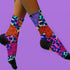 Stylish jungle-themed socks with tigers and abstract camo patterns in a palette of purple, blue, and pink, laid out on a yellow background, ideal for adding a pop of color to your wardrobe