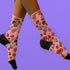 Cute mushroom-themed pink socks with various fungi and nature illustrations, black heels and toes, ideal for casual wear or gifting