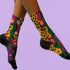 Colorful dopamine-infused crew socks with an all-over print featuring abstract flowers and leopard spots in bold hues of pink, purple, yellow, green, and black. Made of plush polyester-spandex blend, with black toe and heel accents. Designed to fit women’s US 5 to men’s US 12 shoe sizes.