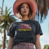 Faded vintage Black t-shirt with "Cat Ladies for Kamala" in retro-style pink and yellow lettering. Cat silhouettes accent the text.