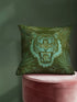 Square woven pillow featuring fierce turquoise tiger with bared fangs against olive green background surrounded by jungle leaves. Textured tapestry creates vibrant mid-century tiki decor perfect for rockabilly, maximalist room styling.
