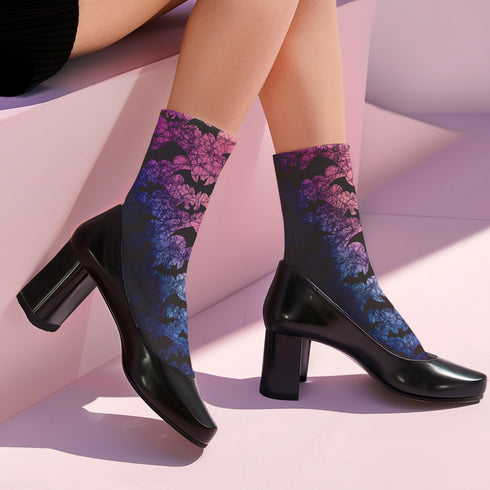 Black crew socks featuring an ombre pink-to-blue gradient with silhouetted bats and spiderweb details.