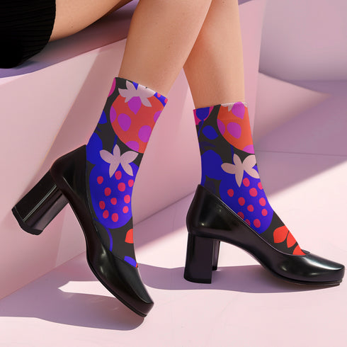 Black crew socks featuring an oversized, abstract strawberry pattern in bright pink, blue, and orange.