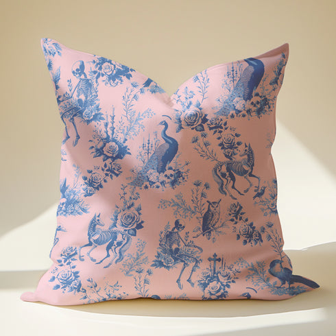 Luxury throw pillow cover featuring a gothic toile pattern in deep blue on a soft pink background, with skeletal figures, peacocks, and floral motifs.
