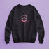 a black sweatshirt featuring a psychedelic "Eat the Rich" design with an eyeball and vampire teeth,