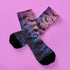 Black crew socks featuring an ombre pink-to-blue gradient with silhouetted bats and spiderweb details.
