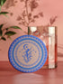 Round ceramic coaster featuring a silhouetted dancing figure reaching toward a crescent moon, surrounded by concentric rings of stars and floral patterns in blue on peach background
