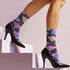 Black crew socks with an allover design of iridescent neon mushrooms in shades of pink, blue, and purple.