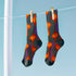 Black crew socks featuring a fiery red, orange, and purple lava-lamp-inspired wave pattern.