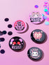 A set of five glossy round pinback buttons with pastel goth and kawaii punk designs, featuring slogans like "Eat The Rich" and "Stop Fascism" in bold pink and black. Each pin has a cute character with a rebellious message.