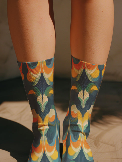 Crew socks featuring a bold ‘70s-style abstract swirl pattern in deep green, orange, yellow, and navy blue.