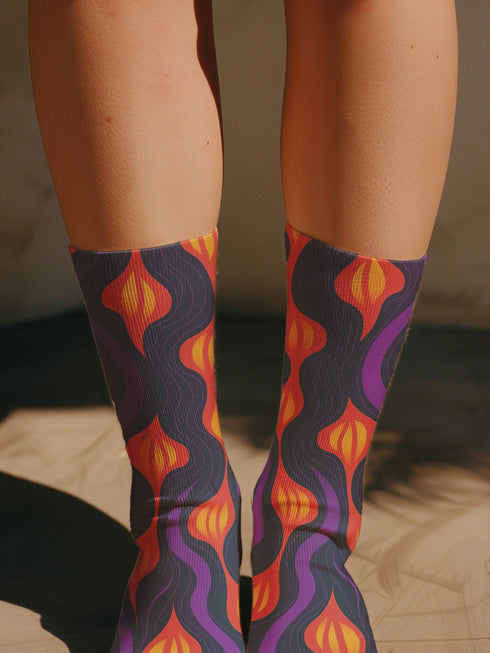 Black crew socks featuring a fiery red, orange, and purple lava-lamp-inspired wave pattern.