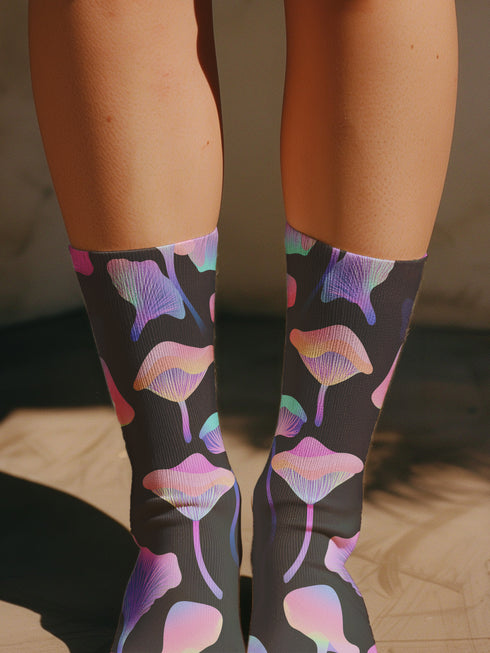 Black crew socks with an allover design of iridescent neon mushrooms in shades of pink, blue, and purple.