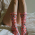 Cute mushroom-themed pink socks with various fungi and nature illustrations, black heels and toes, ideal for casual wear or gifting