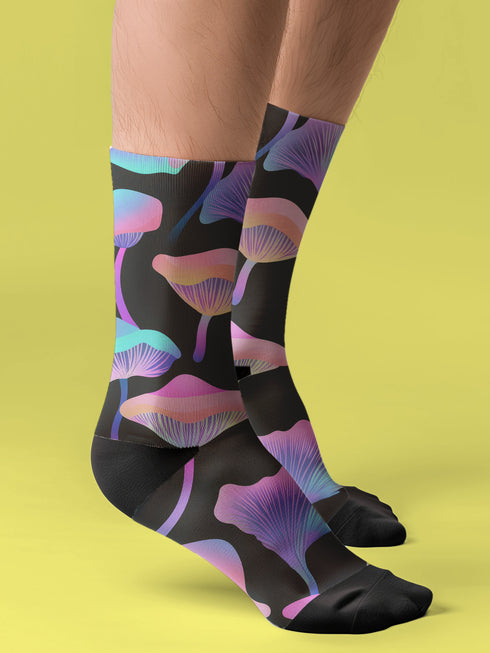 Black crew socks with an allover design of iridescent neon mushrooms in shades of pink, blue, and purple.