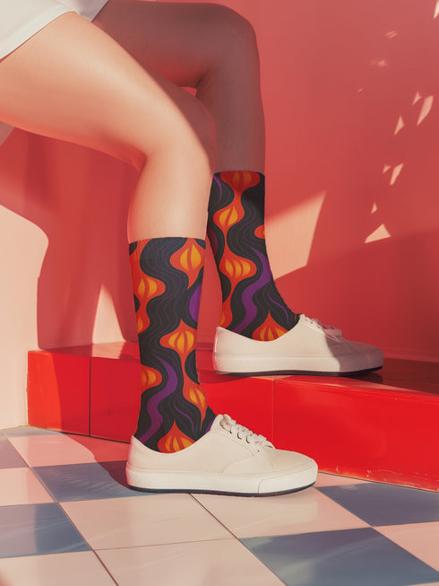 Black crew socks featuring a fiery red, orange, and purple lava-lamp-inspired wave pattern.