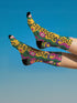 Colorful dopamine-infused crew socks with an all-over print featuring abstract flowers and leopard spots in bold hues of pink, purple, yellow, green, and black. Made of plush polyester-spandex blend, with black toe and heel accents. Designed to fit women’s US 5 to men’s US 12 shoe sizes.