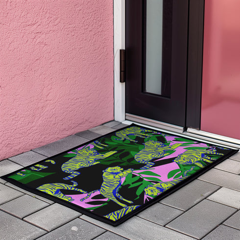 Vibrant doormat featuring stylized yellow tigers with blue stripes amidst green foliage and pink accents on a black background. Bold, maximalist design for indoor/outdoor use.