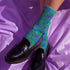 un and playful socks adorned with vibrant tiger head motifs on a green background, with black heels and toes, ideal for animal lovers and those who enjoy unique designs
