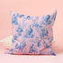 Luxury throw pillow cover featuring a gothic toile pattern in deep blue on a soft pink background, with skeletal figures, peacocks, and floral motifs.