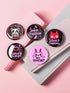 A set of five glossy round pinback buttons with pastel goth and kawaii punk designs, featuring slogans like "Eat The Rich" and "Smash Fascism" in bold pink and black. Each pin has a cute character delivering a powerful message.