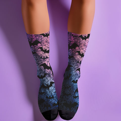 Black crew socks featuring an ombre pink-to-blue gradient with silhouetted bats and spiderweb details.
