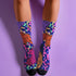 Stylish jungle-themed socks with tigers and abstract camo patterns in a palette of purple, blue, and pink, laid out on a yellow background, ideal for adding a pop of color to your wardrobe