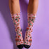 Cute mushroom-themed pink socks with various fungi and nature illustrations, black heels and toes, ideal for casual wear or gifting