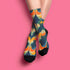 Crew socks featuring a bold ‘70s-style abstract swirl pattern in deep green, orange, yellow, and navy blue.