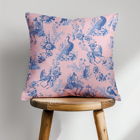 Luxury throw pillow cover featuring a gothic toile pattern in deep blue on a soft pink background, with skeletal figures, peacocks, and floral motifs.