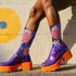 Black crew socks featuring an oversized, abstract strawberry pattern in bright pink, blue, and orange.