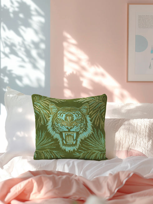 Square woven pillow featuring fierce turquoise tiger with bared fangs against olive green background surrounded by jungle leaves. Textured tapestry creates vibrant mid-century tiki decor perfect for rockabilly, maximalist room styling.