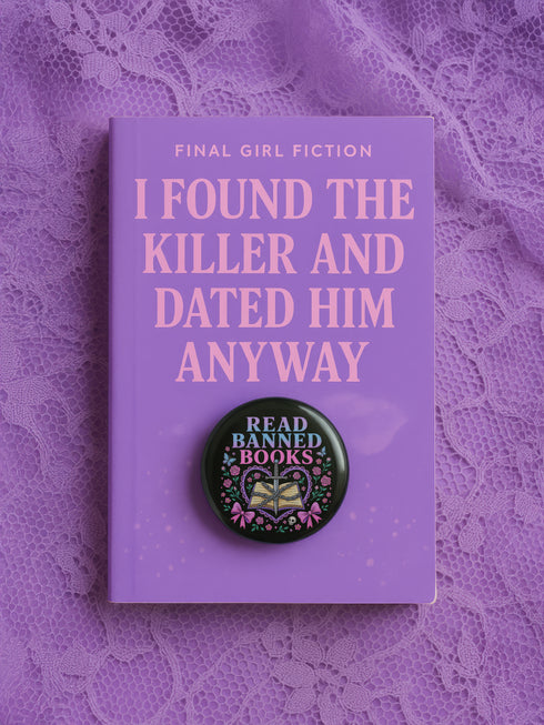 Glossy black pinback button that says “Read Banned Books” in purple and teal letters, featuring a chained book, roses, bows, and floral accents, styled on colorful books and pastel backgrounds.