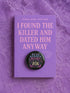 Glossy black pinback button that says “Read Banned Books” in purple and teal letters, featuring a chained book, roses, bows, and floral accents, styled on colorful books and pastel backgrounds.