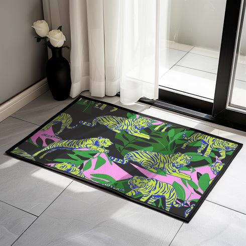 Vibrant doormat featuring stylized yellow tigers with blue stripes amidst green foliage and pink accents on a black background. Bold, maximalist design for indoor/outdoor use.