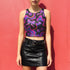 Honey Dazed Brand body-hugging racerback crop top featuring Y2K-inspired print with purple gradient cherries, holographic bows, and swirling patterns in pink, purple, and blue on black background in performance knit fabric