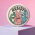 A round white pinback button with the word 'RESIST' in a bold, black, arched font. Below the text stand three cute cartoon characters raising their fists in protest: a green frog with a blue bandana, a pink bunny with '/BAD' on its chest, and a blue shark with sharp teeth. The activist pin has a glossy, protective mylar finish and a durable metal shell, designed as political statement flair for jackets, bags, and backpacks. This punk-inspired, kawaii- badge is a symbol of joyful rebellion.