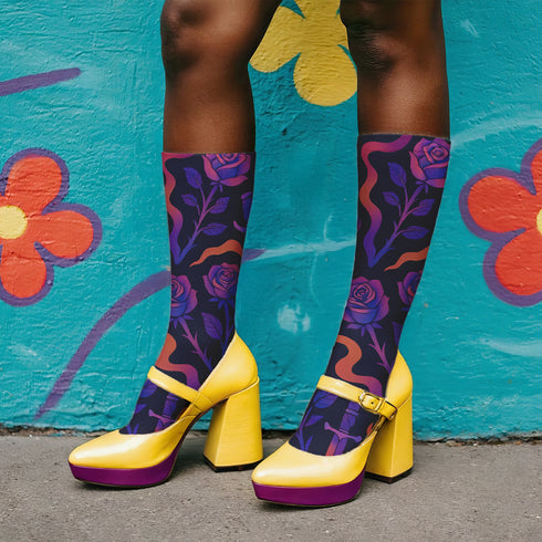 Mid-calf socks with a dark violet-black base featuring a gothic dagger and rose design in gradient shades of red, purple, and pink, with black heels and toes and an illustrated snake detail.
