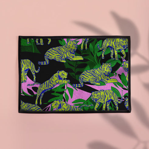 Vibrant doormat featuring stylized yellow tigers with blue stripes amidst green foliage and pink accents on a black background. Bold, maximalist design for indoor/outdoor use.