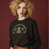 Christmas sweatshirt with "SEASONS SCREAMINGS, DARKLING" text arched over a skull wearing Santa hat. Bats, flowers, and ornate designs surround the skull in vintage-inspired style.