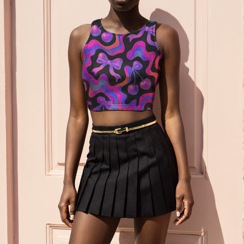 Honey Dazed Brand body-hugging racerback crop top featuring Y2K-inspired print with purple gradient cherries, holographic bows, and swirling patterns in pink, purple, and blue on black background in performance knit fabric
