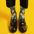 Crew socks featuring a bold ‘70s-style abstract swirl pattern in deep green, orange, yellow, and navy blue.