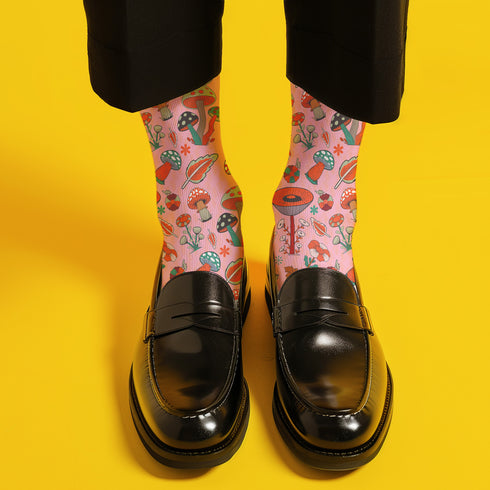 Cute mushroom-themed pink socks with various fungi and nature illustrations, black heels and toes, ideal for casual wear or gifting