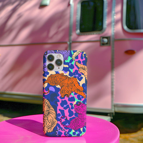 Vibrant phone case with orange tigers on colorful abstract background. Maximalist design featuring multiple tigers and bold purple, pink, and blue patterns. Copy
