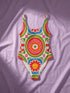 A one-piece swimsuit with a 1970s retro psychedelic geometric pattern in red, orange, green, and blue on a cream background. The swimsuit features a scoop neck and cheeky high-cut fit. In one view, she styles it with a pink baseball cap and gold necklaces. The design includes a central radial sunburst mandala and checkerboard side panels, representing a maximalist, rockstar-ready aesthetic.
