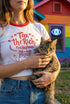 White women's cropped ringer t-shirt with bright red trim on the collar and sleeves. The chest features a cute kawaii graphic in red and soft pink. The text reads "Tax the Rich" in a retro serif font, followed by "Feed the Poor" and "Pet the Cats" in script and sans-serif. Surrounding the text are hearts, sparkles, and flowers. At the bottom, a happy line-art cat with closed smiling eyes raises its paws in the air. The style is flat, 2D, and anime-inspired.