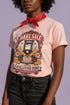 A short sleeve unisex crewneck t-shirt featuring a vintage style emblem graphic centered on the chest. The design features a red banner reading BAKE SALE above a black guillotine. Two crossed wooden rolling pins sit below the guillotine, above a layered pink and white cake with a cherry. The graphic is flanked by pink flowers, cherries, and stacks of gold coins. A bottom banner reads FOR THE GUILLOTINE FUND EST. WHENEVER THEY GOT TOO GREEDY. The shirt comes in light pink, cream, and blue.